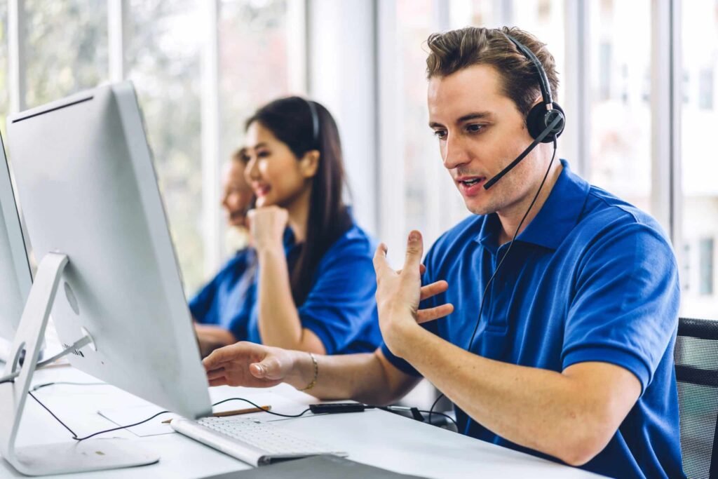 Agente de atención al cliente hablando con auriculares frente a ordenador